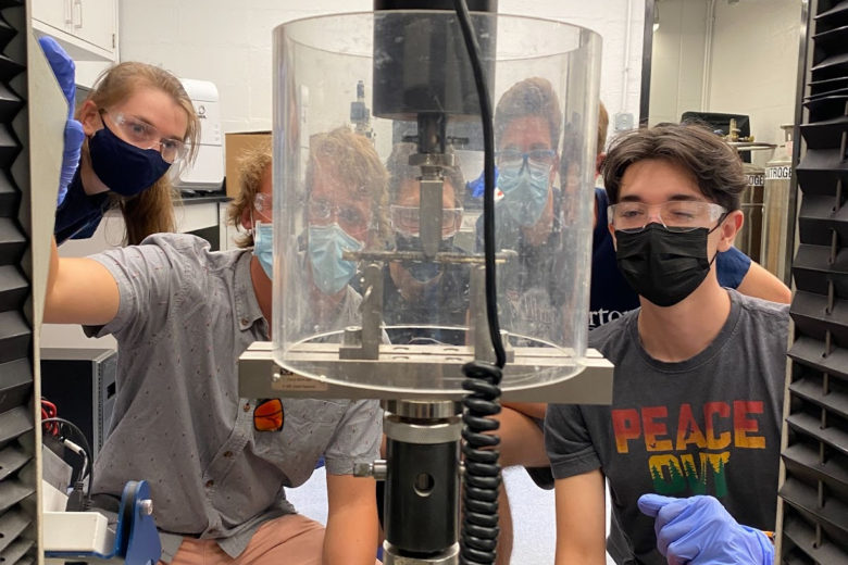 Students in masks look on at